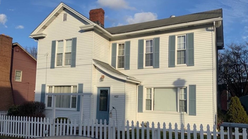 before house with dated siding and old roof